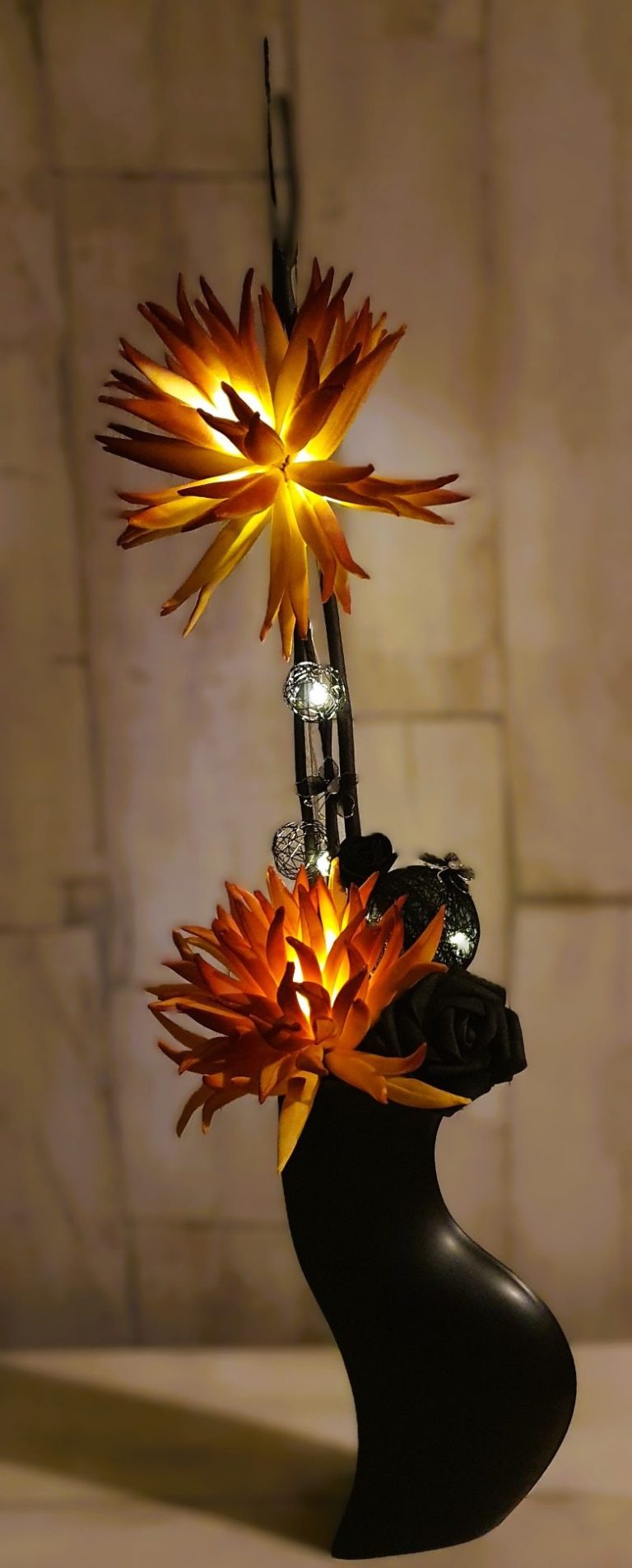 Lampe décorative avec un support en forme de tête et des éléments lumineux en étoile.